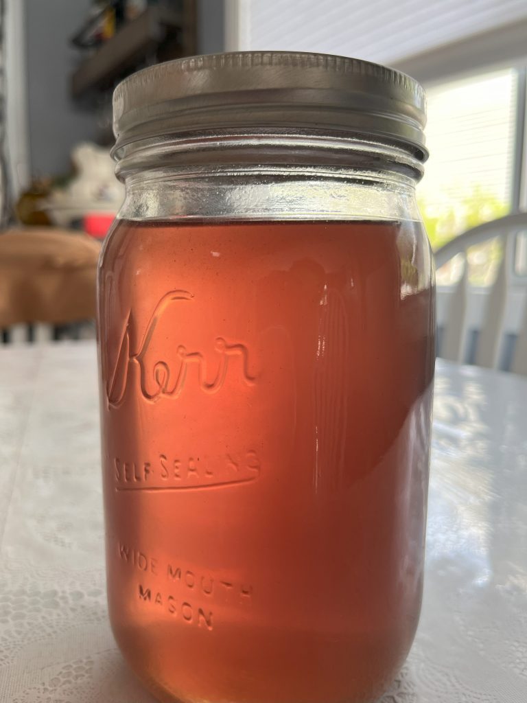 A finished mason jar of lilac syrup